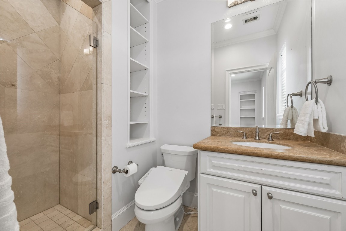 4022 Coleridge Street Houston, TX 77005 - Photo 25 of 31 Well-appointed bathroom with marble countertops, custom cabinetry, and glass-enclosed shower.