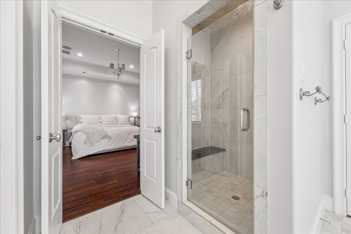 4022 Coleridge Street Houston, TX 77005 - Photo 28 of 31 Walk-in marble shower with frameless glass enclosure and built-in bench.