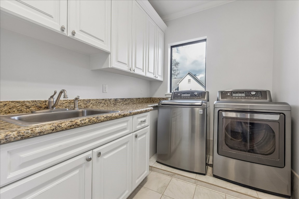 4022 Coleridge Street Houston, TX 77005 - Photo 30 of 31 Functional laundry room with granite countertops, built-in cabinetry, utility sink, and stainless washer and dryer.