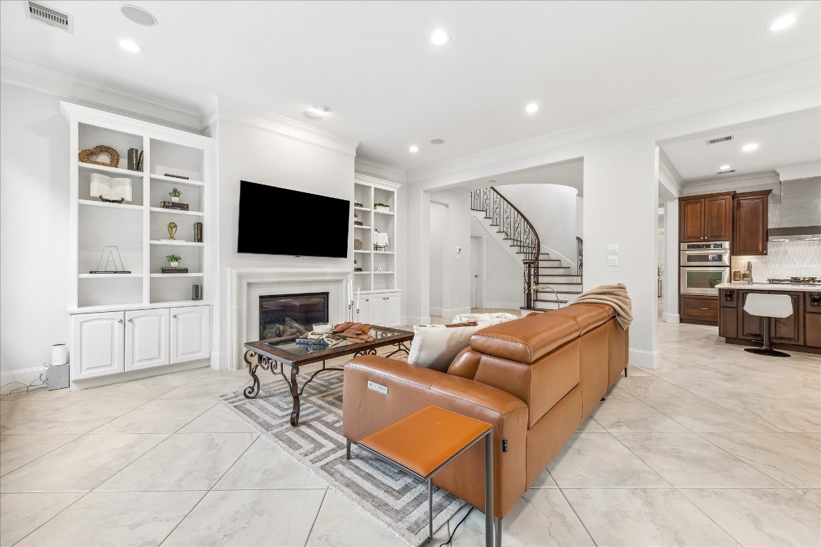 4022 Coleridge Street Houston, TX 77005 - Photo 7 of 31 Open living area with designer lighting, built-ins, and seamless flow to the kitchen and dining spaces.