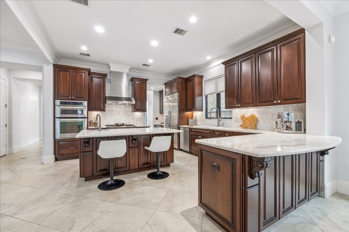 4022 Coleridge Street Houston, TX 77005 - Photo 10 of 31 Chef’s kitchen with marble countertops, custom cabinetry, professional-grade stainless appliances, and oversized island seating.