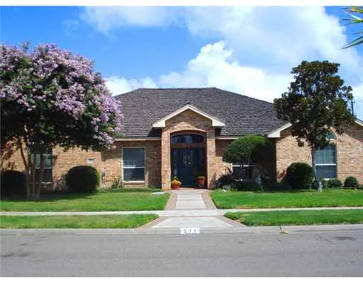 a front view of a house with a yard and trees
