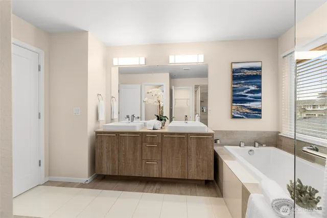 a bathroom with a tub sink and mirror