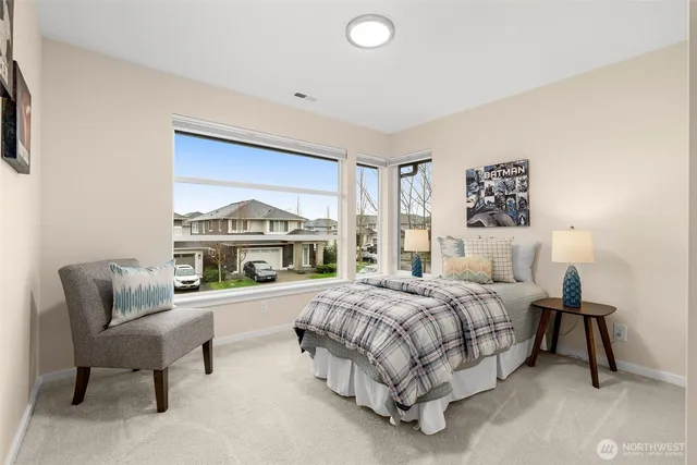 a bedroom with a bed a table and a painting on the wall