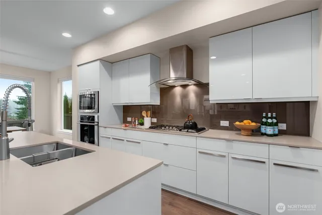 a kitchen with stainless steel appliances a sink a stove and cabinets
