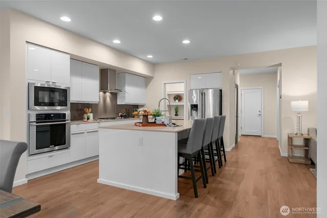 a kitchen with a sink a counter top space stainless steel appliances and cabinets