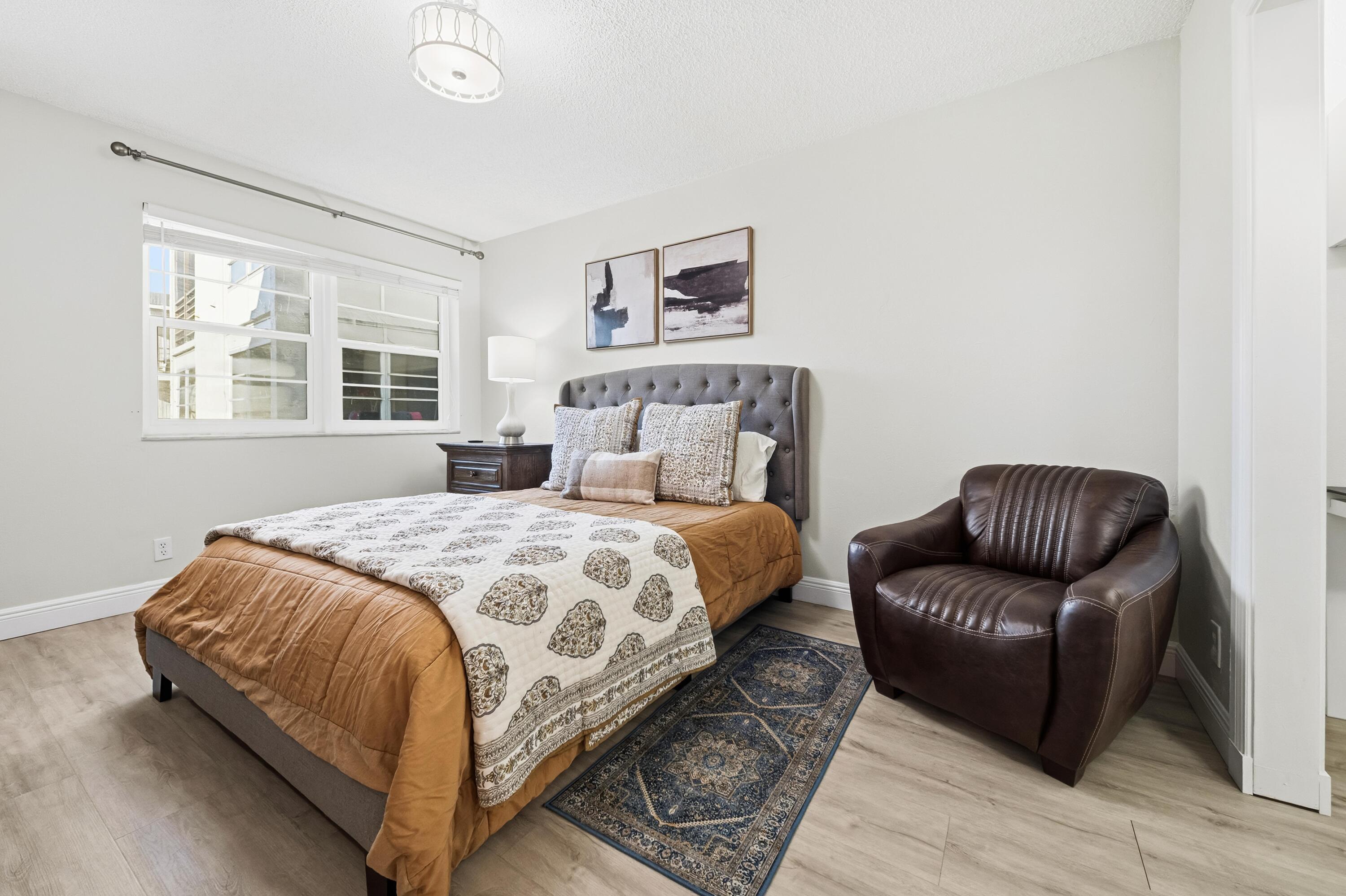 9440 Southwest 8th Street, Unit 314 Boca Raton, FL 33428 - Photo 11 of 30 a bedroom with a large bed and a couch