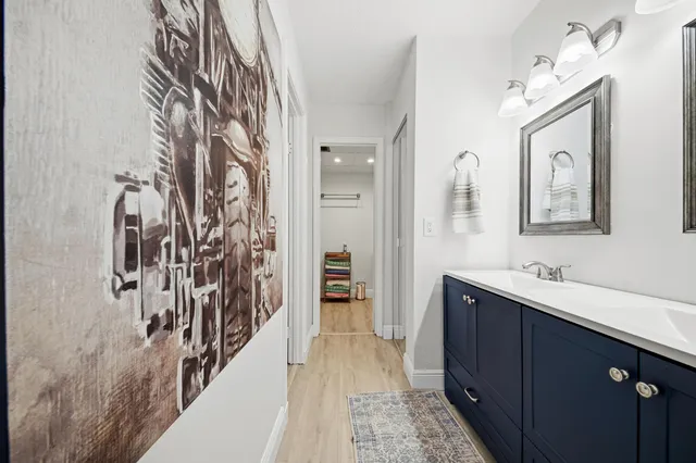 a hallway with a large mirror and cabinets