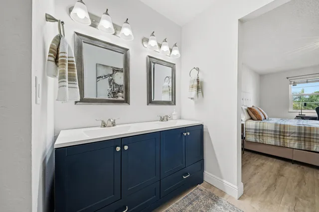 a bathroom with a double vanity sink mirror and bathtub