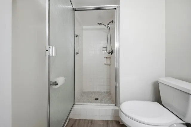a bathroom with a shower a toilet and a sink