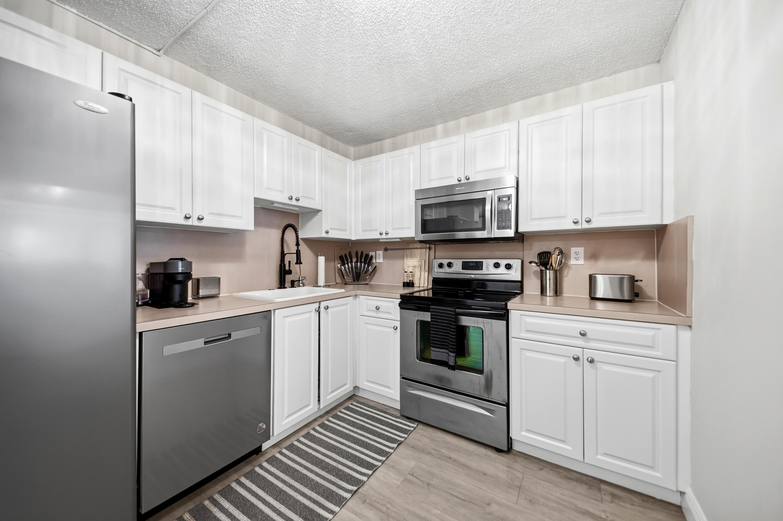 9440 Southwest 8th Street, Unit 314 Boca Raton, FL 33428 - Photo 2 of 30 a kitchen with cabinets stainless steel appliances and a sink