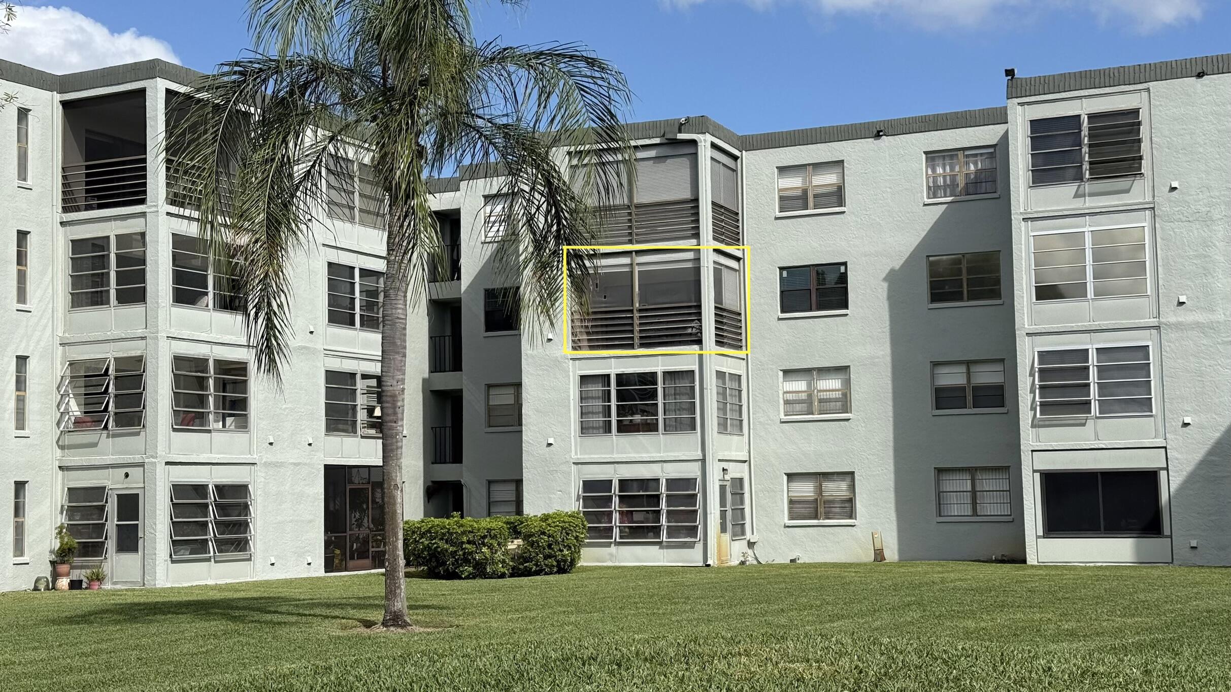 9440 Southwest 8th Street, Unit 314 Boca Raton, FL 33428 - Photo 25 of 30 a front view of a residential apartment building with a yard