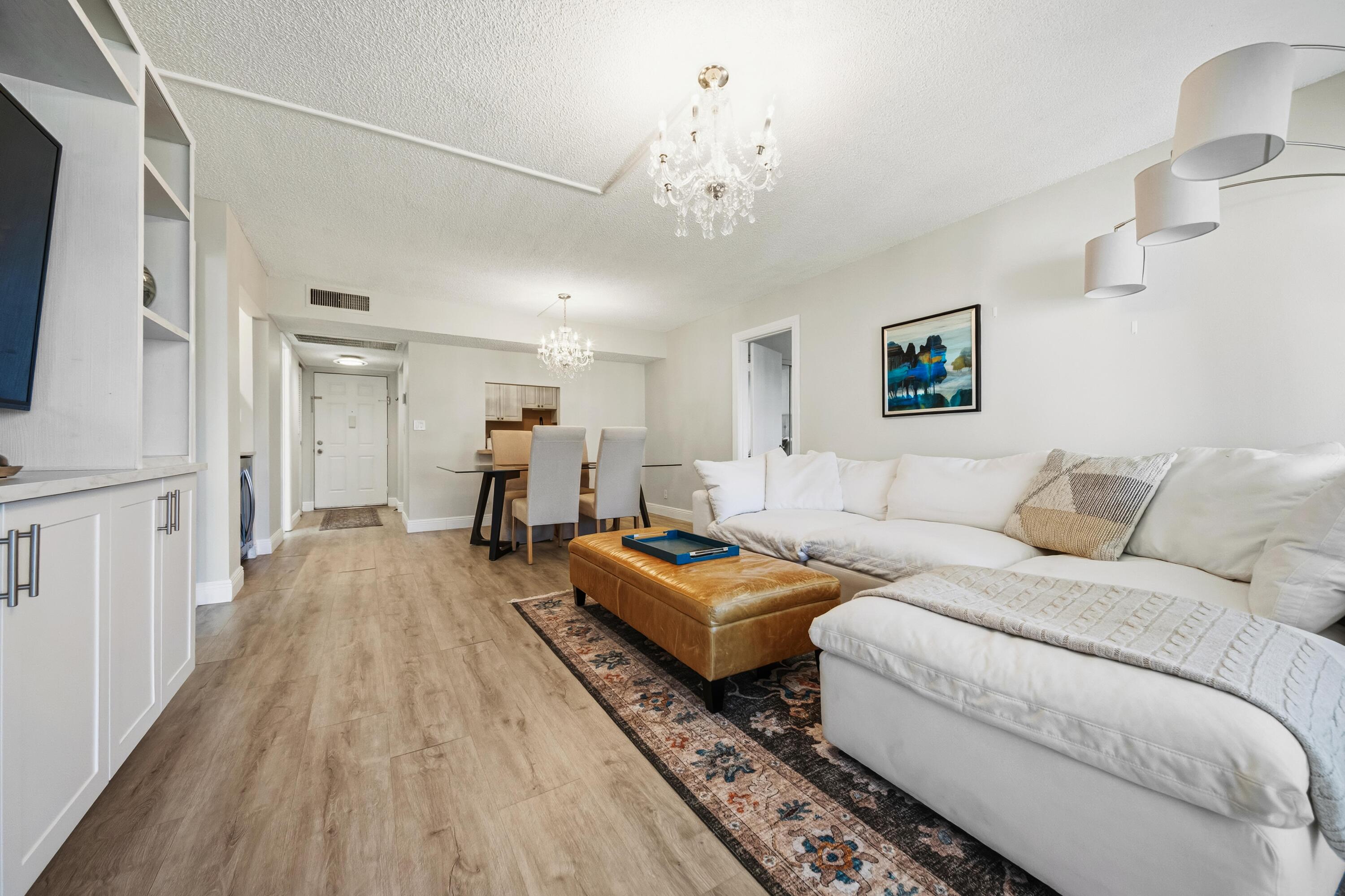 9440 Southwest 8th Street, Unit 314 Boca Raton, FL 33428 - Photo 10 of 30 a living room with furniture and a chandelier