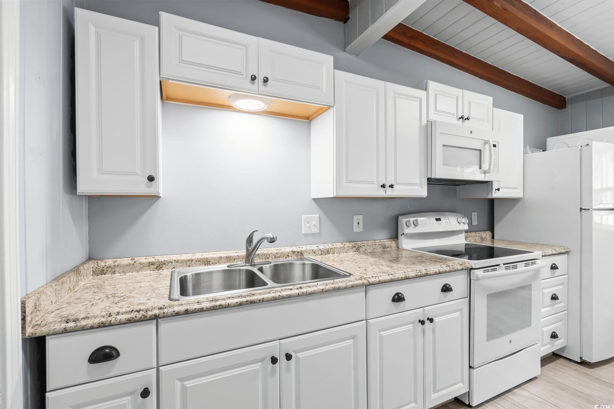 3402 Turner Street North Myrtle Beach, SC 29582 - Photo 8 of 26 Kitchen with white appliances, white cabinets, light stone countertops, and light wood-style flooring