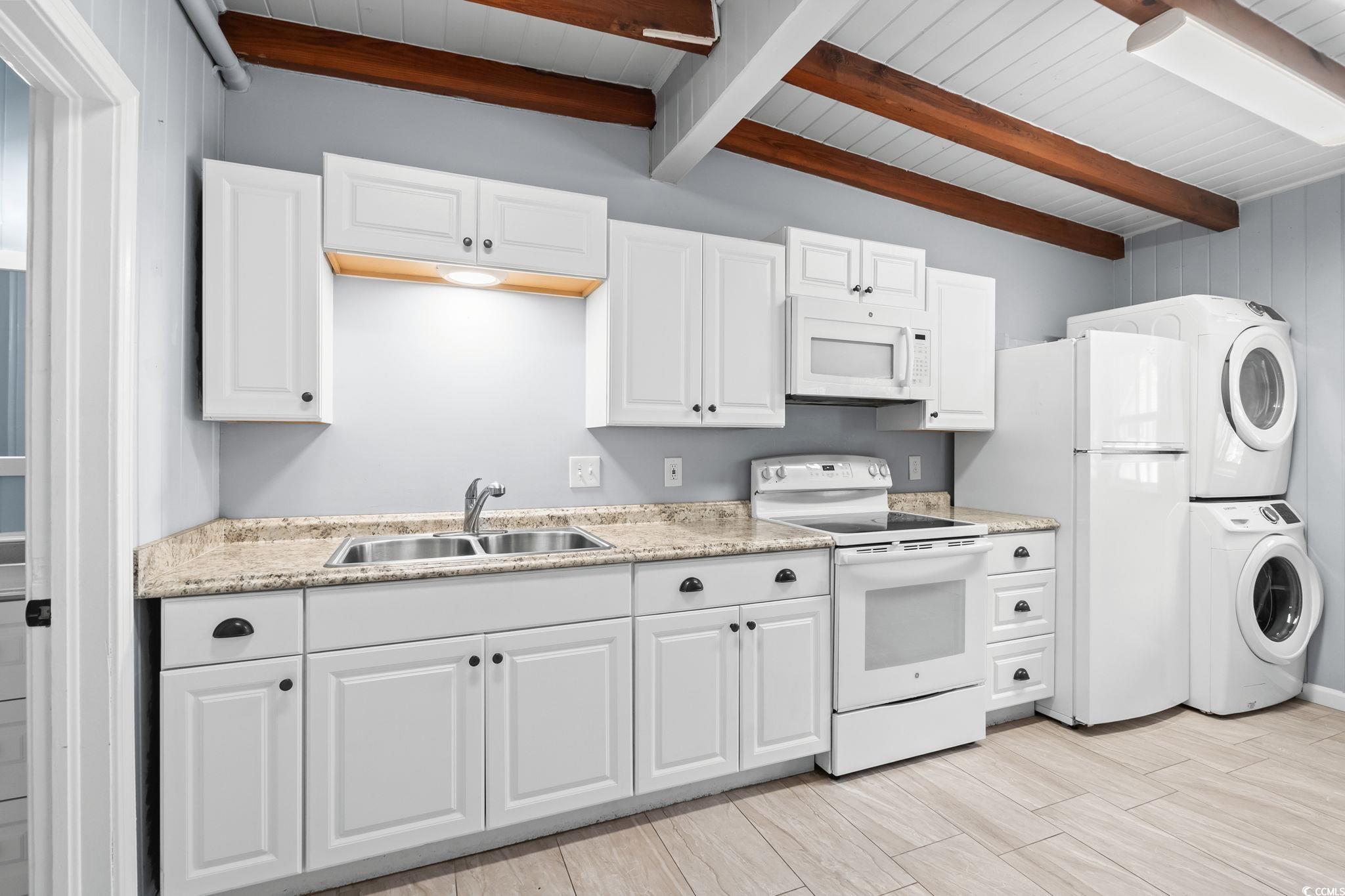 3402 Turner Street North Myrtle Beach, SC 29582 - Photo 9 of 26 Kitchen featuring white appliances, white cabinets, stacked washer / dryer, wood tiled floors, and beamed ceiling
