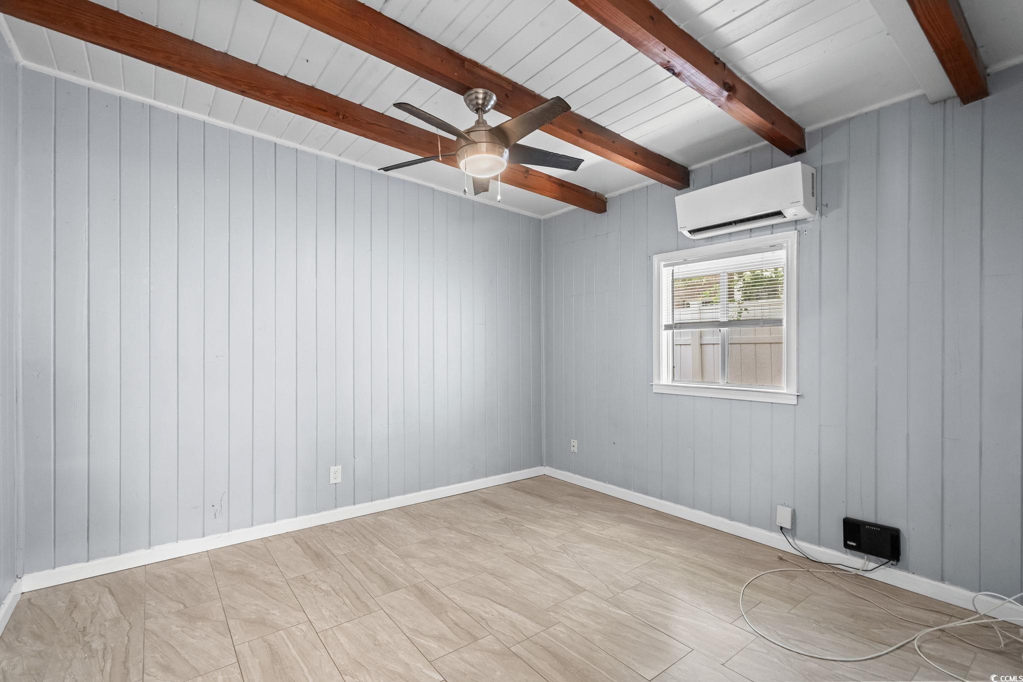 3402 Turner Street North Myrtle Beach, SC 29582 - Photo 10 of 26 Empty room featuring ceiling fan, an AC wall unit, wooden walls, and beamed ceiling