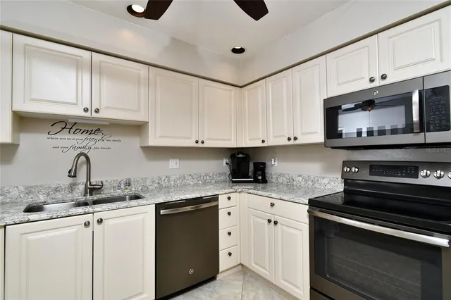 a kitchen with stainless steel appliances granite countertop a sink a stove a microwave and cabinets