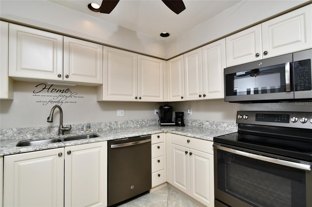 2060 Matecumbe Key Road, Unit 2102 Punta Gorda, FL 33955 - Photo 7 of 36 a kitchen with stainless steel appliances granite countertop a sink a stove a microwave and cabinets