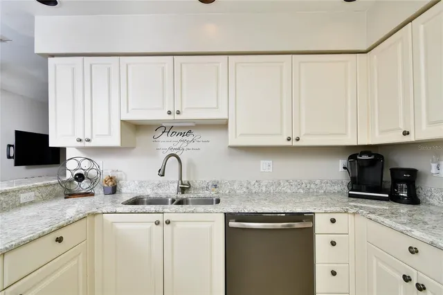 a kitchen with granite countertop white cabinets and white appliances