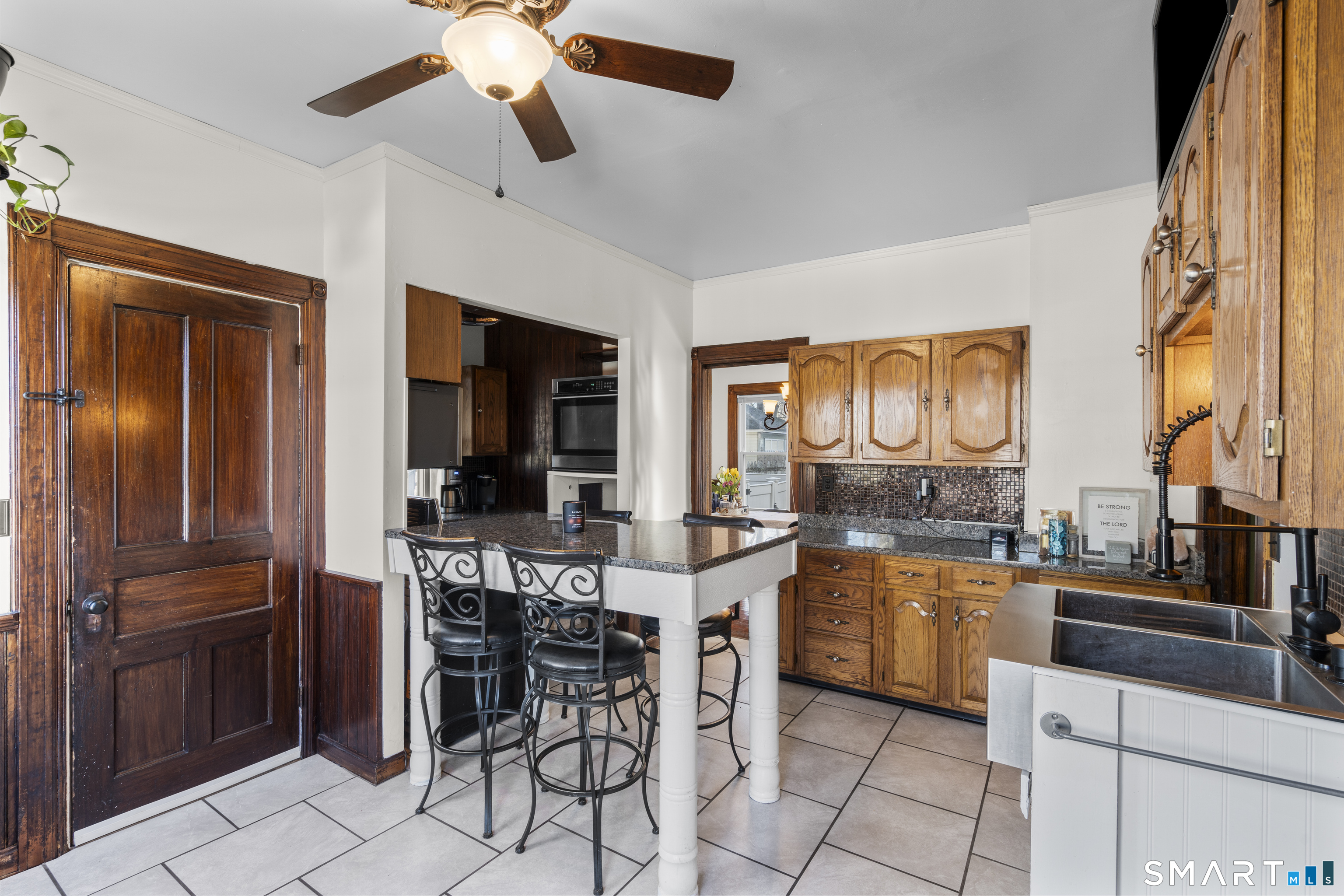 101 Wilcox Avenue Meriden, CT 06451 - Photo 18 of 43 a kitchen with stainless steel appliances kitchen island granite countertop a stove top oven a sink a dining table and chairs with wooden floor