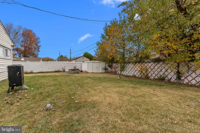 a view of a yard with wooden fence