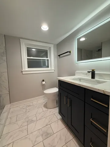 a bathroom with a sink a toilet and mirror