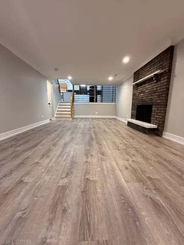a view of empty room with wooden floor and fireplace