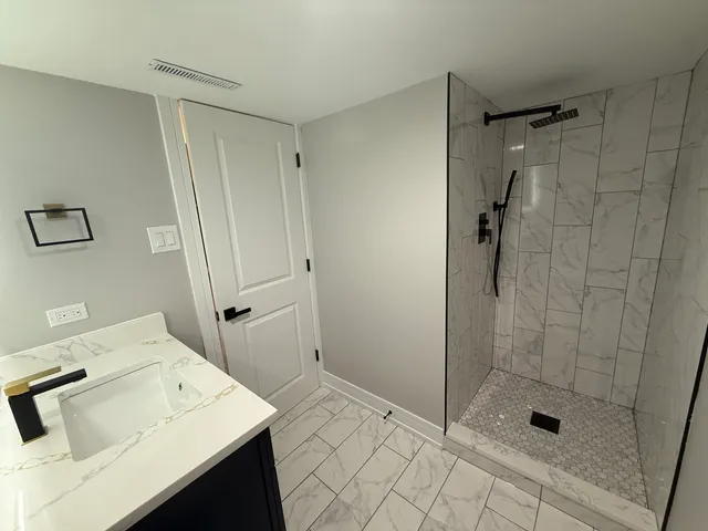 a bathroom with a shower sink and mirror