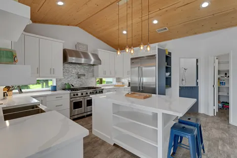a kitchen that has a lot of cabinets a sink and appliances