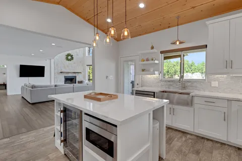 a kitchen that has a sink a stove and a table with chairs