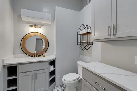 a bathroom with a toilet a sink and a mirror