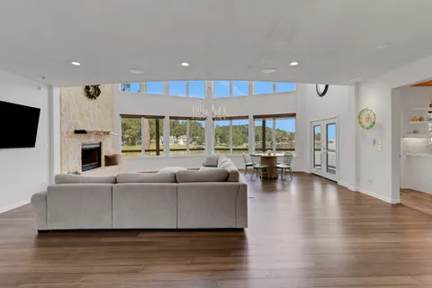 a living room with furniture wooden floor and a large window