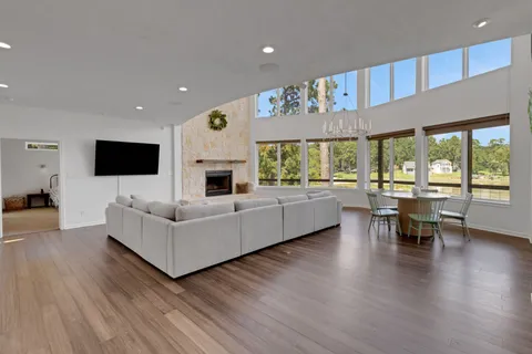 a living room with furniture flat screen tv and a large window