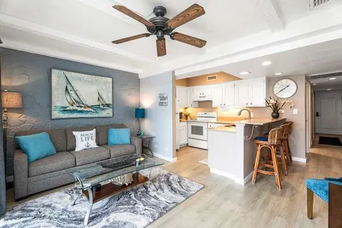 a living room with furniture and kitchen view
