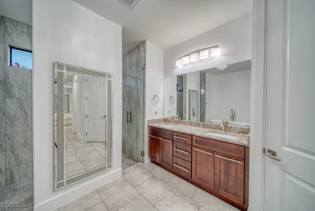 a spacious bathroom with a granite countertop sink mirror and shower
