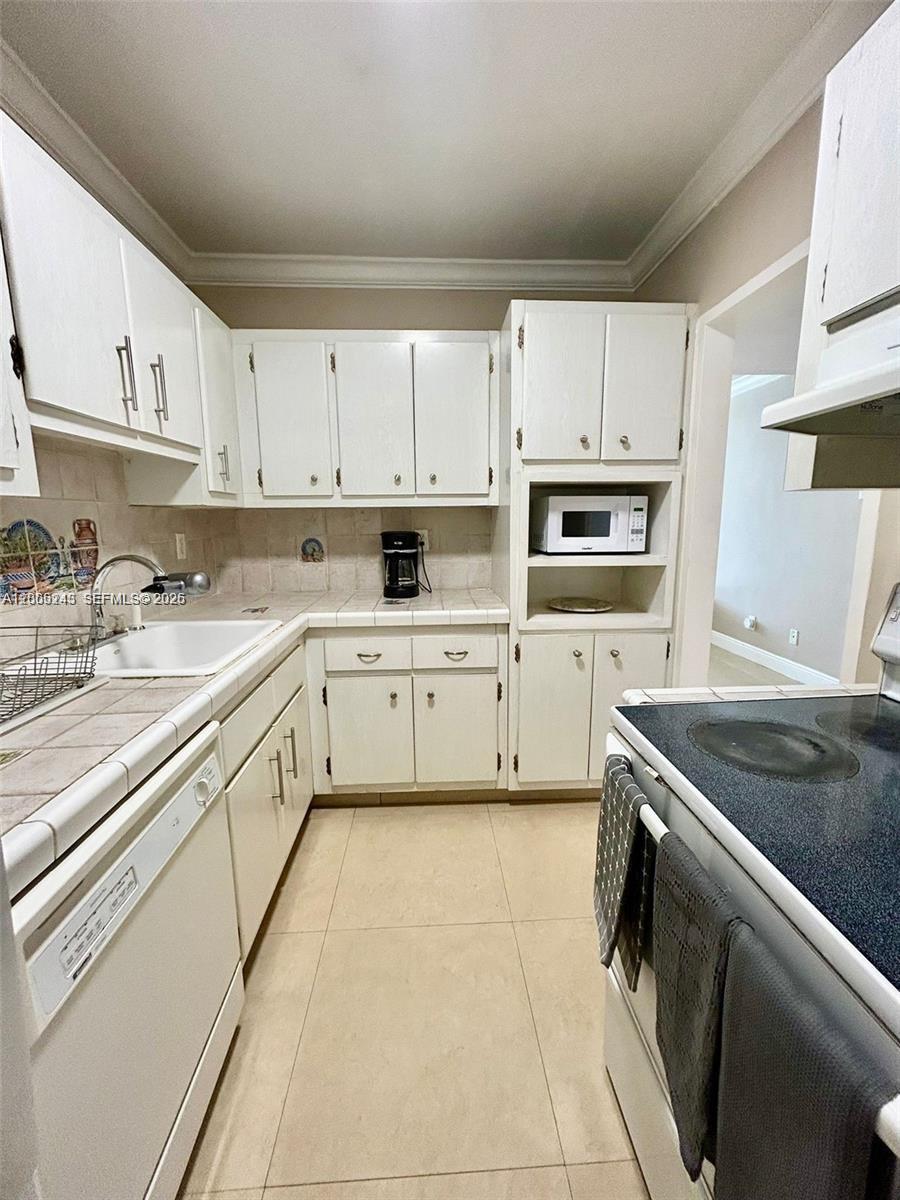 100 Lincoln Road, Unit 1010 Miami Beach, FL 33139 - Photo 4 of 12 a kitchen with cabinets appliances and a sink