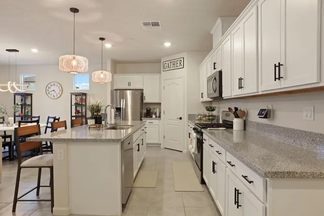 a large kitchen with kitchen island a large counter top space a sink stainless steel appliances and cabinets