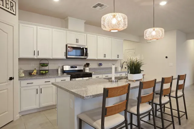a kitchen with cabinets a sink and chairs
