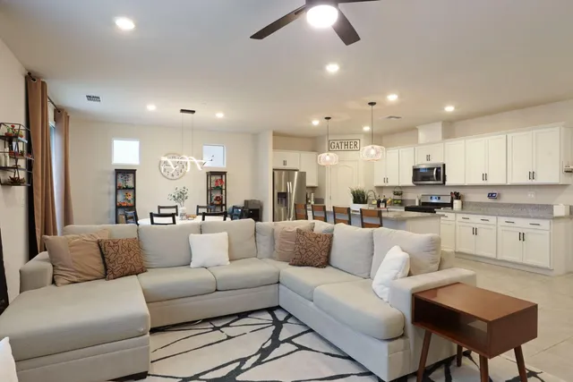 a kitchen with a sink a counter top space and a view of living room