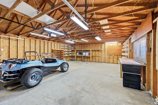 1180 North 400 East Bountiful, UT 84010 - Photo 33 of 50 Spacious garage featuring exposed wood beam ceiling, concrete flooring, fluorescent lighting, and built-in shelving