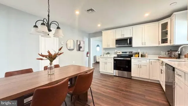 a kitchen with cabinets stainless steel appliances a sink and a stove