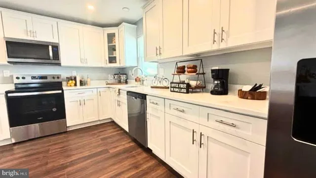 a kitchen with a sink appliances cabinets and furniture