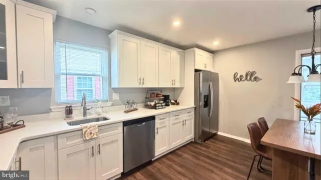 a kitchen with granite countertop a sink appliances cabinets and furniture