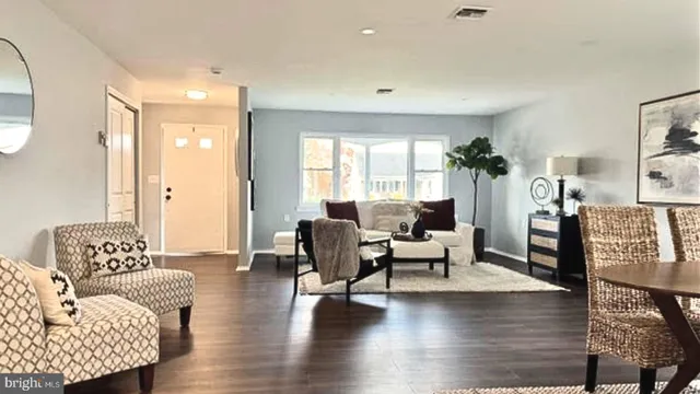a living room with furniture wooden floor and a large window