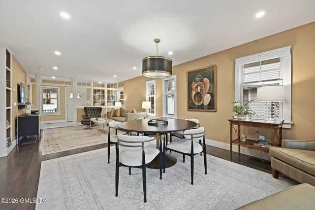 a living room with furniture a dining table and a chandelier