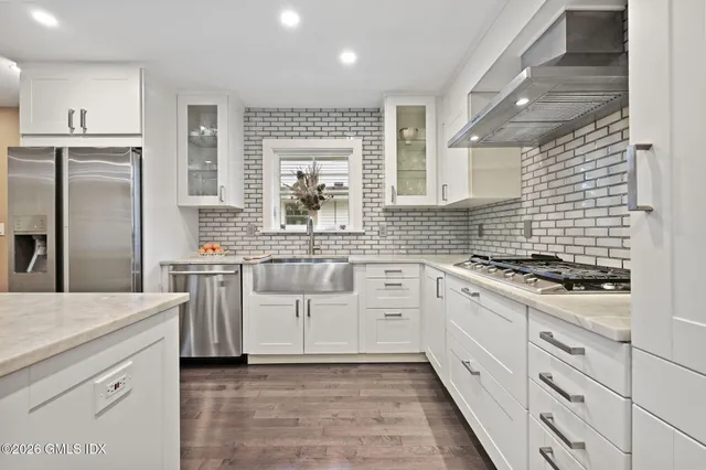 a kitchen with granite countertop a sink stainless steel appliances and cabinets