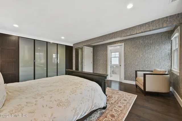 a large bathroom with a toilet a sink a mirror a bathtub and window