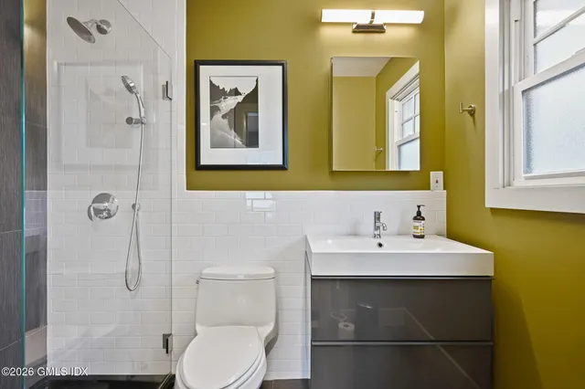a bathroom with a sink mirror and toilet
