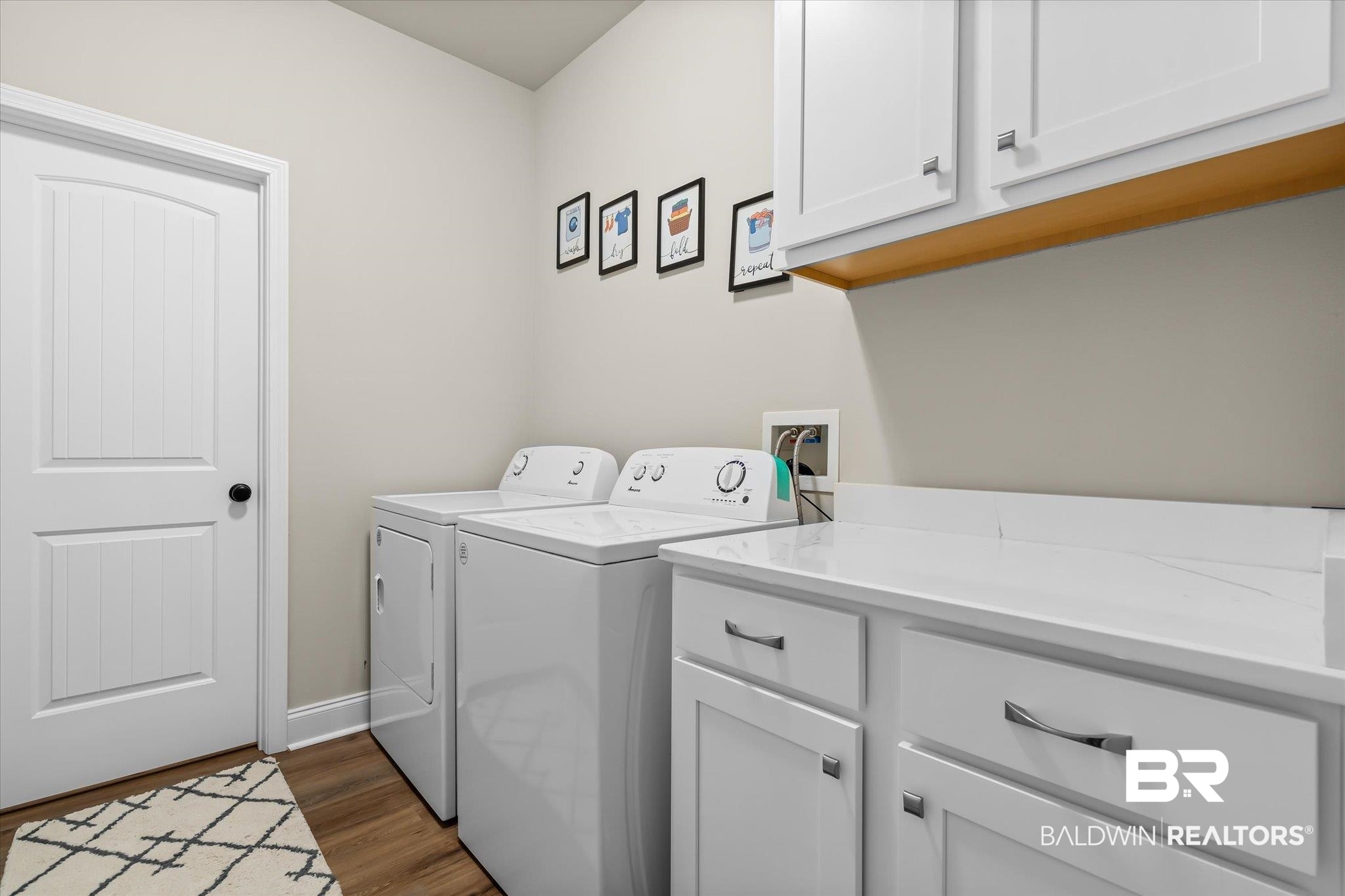 1116 Stella Road Foley, AL 36535 - Photo 23 of 29 Clothes washing area featuring dark wood-type flooring, cabinets, and washing machine and clothes dryer