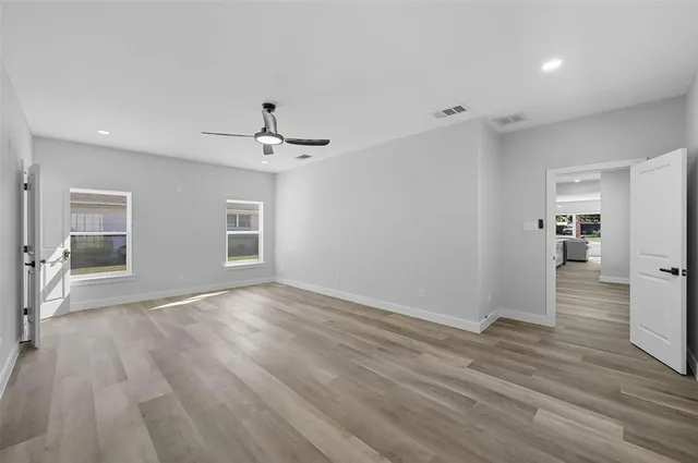 a view of an empty room with wooden floor